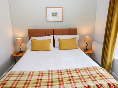 A bedroom with a bed and bedside lamps at Teifi Villa in St Dogmaels