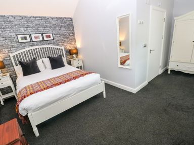 A bedroom with a bed and wardrobe at Teifi Villa in St Dogmaels