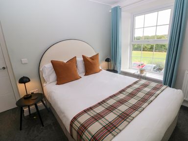 A bedroom with a bed and lamp at Teifi Villa in St Dogmaels