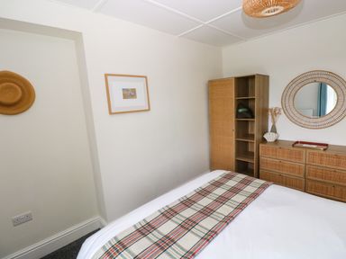 A bedroom with a bed and storage furniture at Teifi Villa in St Dogmaels