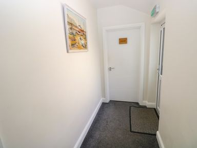A hallway with a painting and a door at Teifi Villa in St Dogmaels