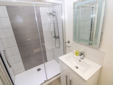 A bathroom with a shower and sink at Teifi Villa St Dogmaels