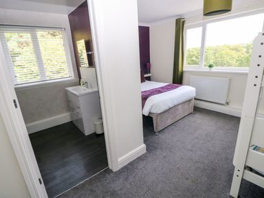 A bedroom with a bed and a bathroom sink at Teifi Villa in St Dogmaels