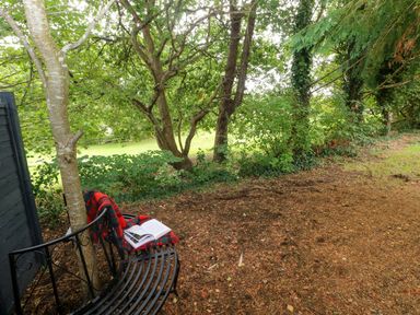A garden area with a bench and a book at Teifi Villa, St Dogmaels