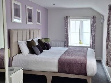 A bedroom with a bed and window at Teifi Villa in St Dogmaels