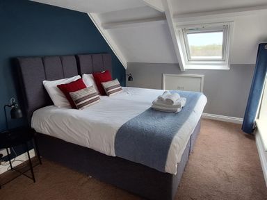 A bedroom with a bed, pillows, and a lamp at Teifi Villa in St Dogmaels