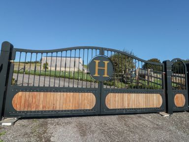 A gate with emblem and a barn in the background at Foxes Den in Allerston near Thornton Dale
