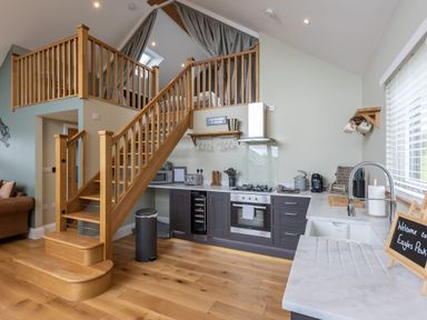 A kitchen with wooden stairs and a countertop with sink at Eagles Peak in Allerton near Thornton-Le-Dale