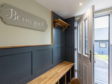 A hallway with a wooden bench and hooks inside a door at Eagles Peak in Allerton near Thornton-Le-Dale