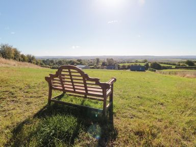 A bench in a grassy area overlooking hills at Eagles Peak in Allerton near Thornton-Le-Dale