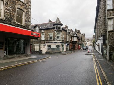 A street with stone buildings and shops including a store with a red sign saying ALPKIT and a solicitors office called Davenport and Scott Solicitors