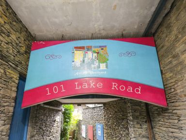 A sign with the text 101 Lake Road above a stone alleyway at Dixon Court Ambleside