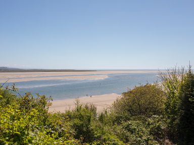 A river estuary with sandbanks and vegetation in the foreground at Hen Beudy in Porthmadog