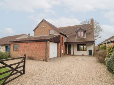 A brick house with a garage and gravel driveway at Morgan House in Middlezoy