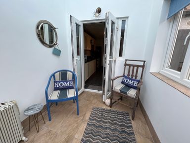 A small indoor seating area with two chairs and a round side table at 57 Southend Road in Hunstanton