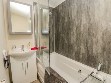 A bathroom with a bathtub sink cabinet mirror and shower at Happy Daze in Carnaby near Bridlington