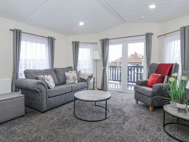 A living room with a sofa and armchair at Happy Daze Carnaby near Bridlington