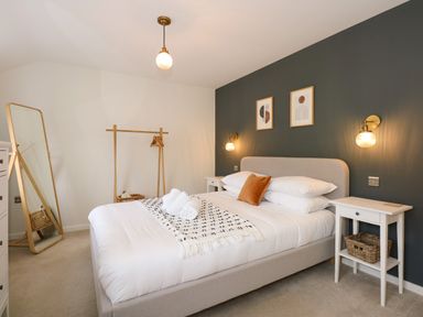 A bedroom with a bed with pillows and bedside tables with lamps at Aran in Beddgelert