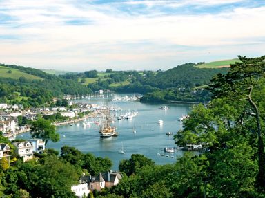A river with boats and houses on the shore surrounded by green hills at Wagtails in Norton near Dartmouth