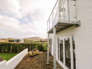 A patio area with glass balcony and white framed doors at The Annex in Ulverston