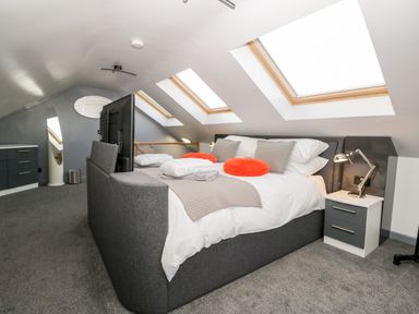 A bedroom with a double bed pillows side tables and skylight windows at The Annex in Ulverston