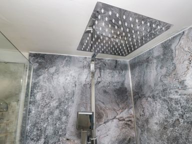 A shower setup with a large shower head and modern faucet at Bay Tree Cottage in Ambleside