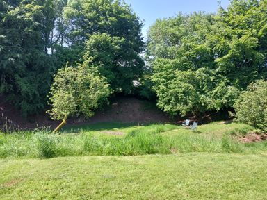 A grassy garden area with trees and two chairs at Orchard Lodge in Hockworthy near Sampford Peverell Devon