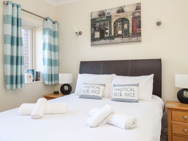 A bedroom with a double bed two side tables and a window with curtains at Ocean Watch 5 in Greenhill