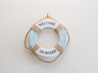 A decorative life buoy with rope and the text welcome on board on a wall at Ocean Watch 5 in Greenhill