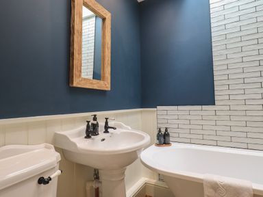 A bathroom with a sink, toilet, and bathtub at The Old Post House at Low Stott Park near Newby Bridge