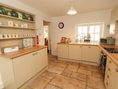 A kitchen with cabinets and a sink at The Old Post House at Low Stott Park near Newby Bridge