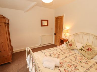 A bedroom with a bed and wardrobe at The Old Post House at Low Stott Park near Newby Bridge