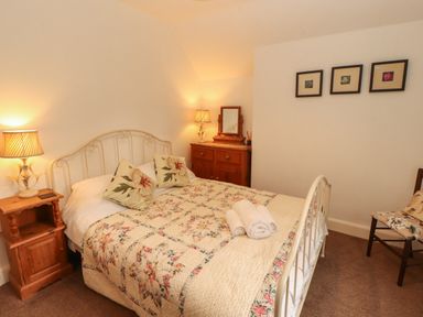 A bedroom with a bed and nightstand at The Old Post House at Low Stott Park near Newby Bridge