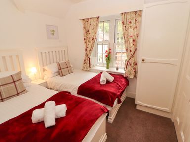 A bedroom with two beds and a window at The Old Post House at Low Stott Park near Newby Bridge