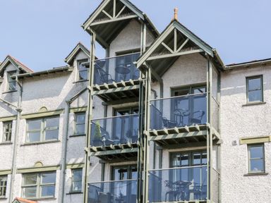 An exterior view of a building with multiple balconies and green window frames at Claife Heights in Windermere