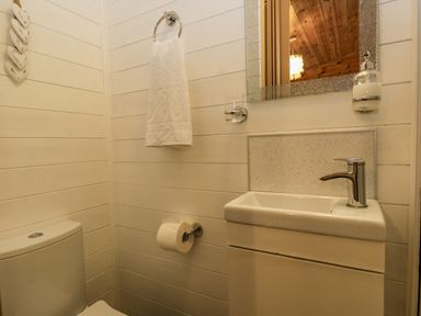 A bathroom with a toilet sink mirror towel and toilet paper at Scafell Lodge Skiptory Howe 7 White Cross Bay Holiday Park near Windermere