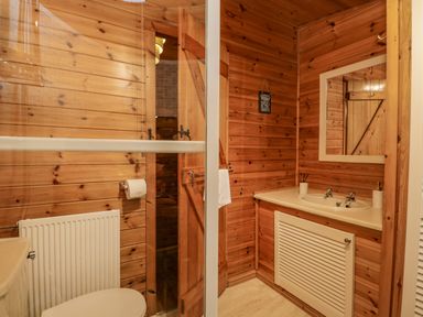 A wooden bathroom with a sink countertop mirror toilet and glass shower door at Scafell Lodge in Skiptory Howe 7 White Cross Bay Holiday Park near Windermere