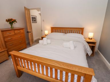 A bedroom with a wooden bed and two bedside tables with lamps at Anchor Cottage in Whitby