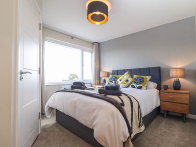 A bedroom with a bed lamps and bedside tables at Pickney House in Killigarth near Polperro