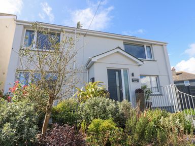 A two-story house with a garden and plants in front at Pickney House Killigarth near Polperro