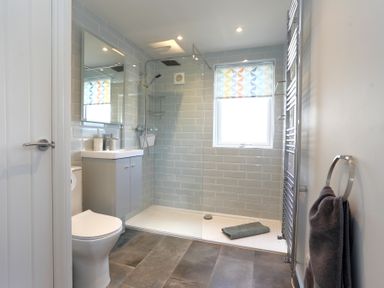 A bathroom with a walk-in shower toilet sink cabinet and towel racks at The Swift in Wem