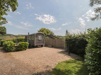An outdoor area with a shepherd's hut and gravel at Acorn in Bleadon