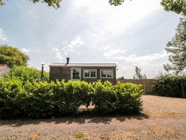 A house with bushes and gravel area at Acorn in Bleadon