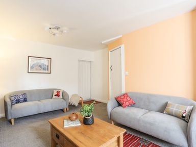 A living room with two gray sofas and a wooden coffee table at 9 Ty Du Road in Llanberis