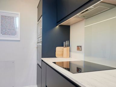A kitchen with a black stovetop knife block and cutting board on the counter at Howe Keld 4 First floor in Keswick
