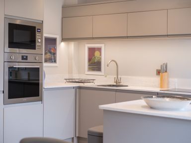 A kitchen with built in oven and microwave a sink with a faucet a knife block and framed pictures on the wall at Howe Keld 5 First Floor Keswick