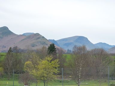 A landscape with mountains trees and grassy fields at Howe Keld 5 First Floor in Keswick