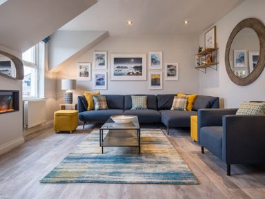 A living room with a sectional sofa pillows and a coffee table at Howe Keld 6 Second Floor in Keswick