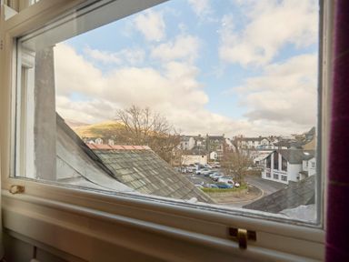 View of rooftops and parked cars outside a window in a town at Howe Keld 6 Second Floor in Keswick
