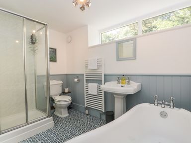 A bathroom with a shower enclosure toilet sink bathtub and towel radiator at Caldhu Cottage in Holmrook